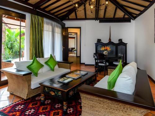 暹粒Angkor Village Resort & Spa的客厅里有一张沙发和一张桌子。