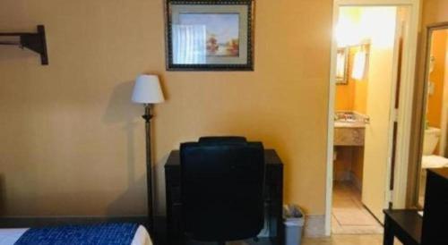 um quarto com uma cama, um candeeiro e um espelho em Travelodge by Wyndham Bay Shore Long Island em Bay Shore