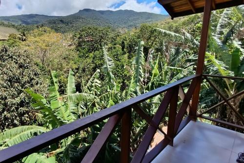 a room with a view of a forest and mountains at Casa Mar A Vista in Ilhabela