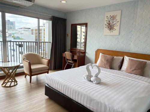 a bedroom with a bed with a stuffed animal on it at OYO 75446 Travis Inthamara 49 in Bangkok