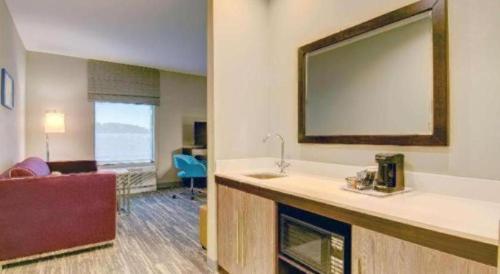 a hotel room with a large mirror above a counter at Hampton Inn Boston/Stoughton in Randolph