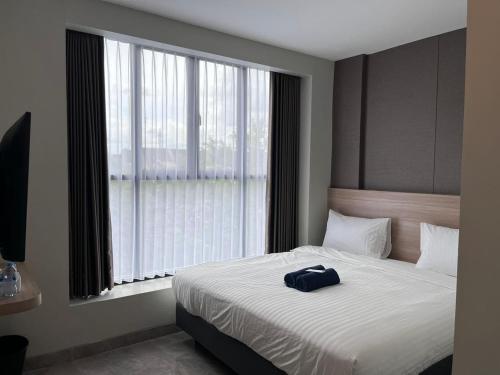 a bedroom with a bed with a blue bag on it at Hotel Cengkareng Inn in Jakarta