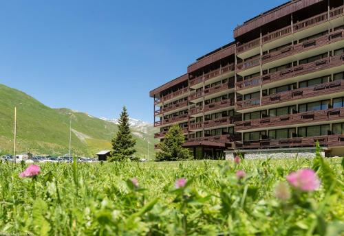 a building with a field of flowers in front of it at Résidence Pierre & Vacances Inter-Résidences in Tignes