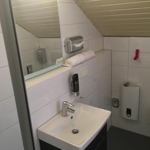 a bathroom with a sink and a mirror at Mille Stelle Hotel in Eggenstein-Leopoldshafen