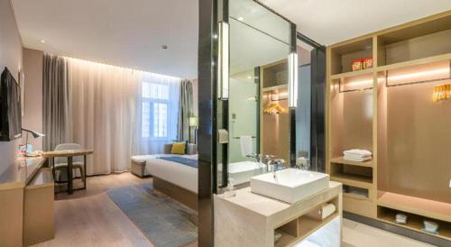 济南Echarm Hotel Jinan Railway Station Daming Lake的配有床、水槽和镜子的浴室