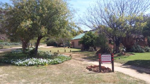 a sign in front of a yard with trees and flowers at Kleinfontein in Clanwilliam