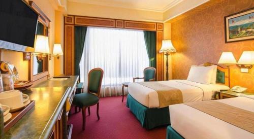 Postel nebo postele na pokoji v ubytování Gajahmada Graha Hotel