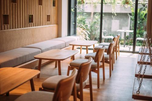 a row of tables and chairs in a restaurant at Mii Hotel Srinakarin in Bangna