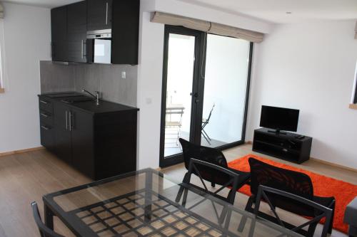 a living room with a table and chairs and a kitchen at Casa Nª Sra. do Carmo - Villas in Peso da Régua