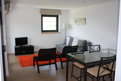 a living room with a table and chairs and a couch at Casa Nª Sra. do Carmo - Villas in Peso da Régua