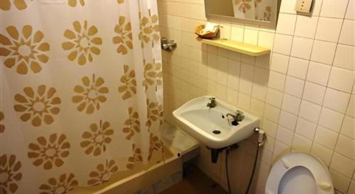 un bagno con lavandino, WC e doccia di Ubon Hotel a Ubon Ratchathani