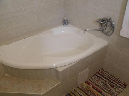 a white bath tub in a tiled bathroom at Apartmanhaz Balatonfenyves in Balatonfenyves