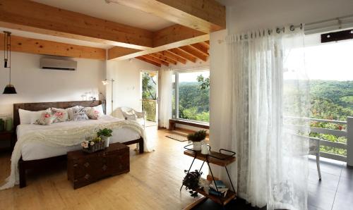 a bedroom with a bed and a large window at Hills & Hues in Thekkady