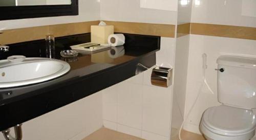 a bathroom with a white toilet and a sink at Casa Boutique Hotel in Phnom Penh