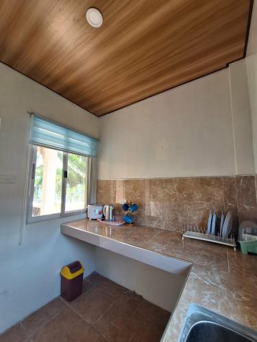 a kitchen with a counter top and a window at Happy's Homestay in Boracay