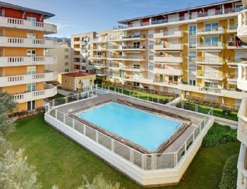 une grande piscine au milieu d'un bâtiment dans l'établissement Appartement Palais des Dômes avec piscine, à Nice