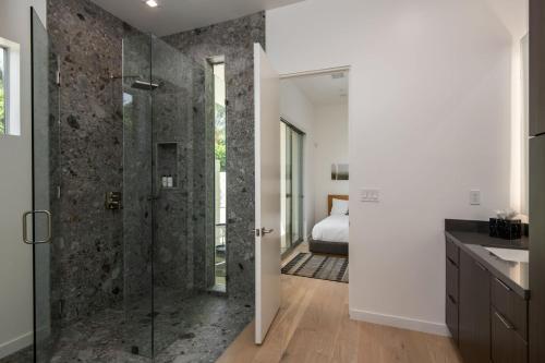 un bagno con doccia in vetro e una camera da letto di Gold @ Elemento49 Pool Pickleball Sleeps 18 a Desert Groves Mobile Home Park