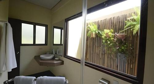 Dalumpinas OesteKahuna Beach Resort and Spa的带淋浴和盥洗盆的浴室以及窗户。