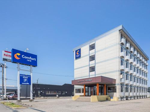un gran edificio blanco con un letrero en la parte delantera en Comfort Inn Niigata Kameda, en Niigata