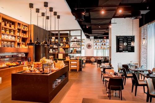 a restaurant with tables and chairs and a bar at Al Maha Arjaan by Rotana in Abu Dhabi