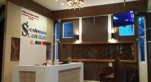 a lobby with a reception desk and a tv at Silayok Grand Hotel in Tak