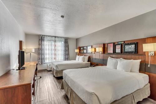 Un pat sau paturi într-o cameră la Clarion Inn Salt Lake City Airport