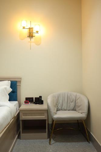 a bedroom with a chair next to a bed at Dibang Hotel & Resort in Mekha