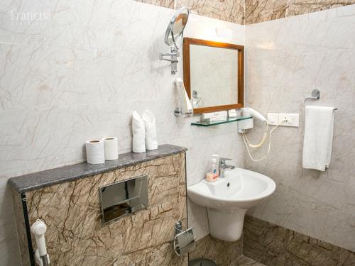 uma casa de banho com um lavatório e um espelho em The Francis Residence em Cochin