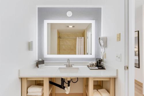 a bathroom with a sink and a mirror at Suburban Studios Salt Lake City Airport in Salt Lake City