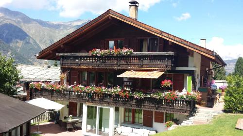 a house with flowers on the balcony of it at Chalet Valerie in Grächen