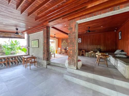 una gran sala de estar con techos y mesas de madera. en Santris Villas by GenuineHost, en Ubud