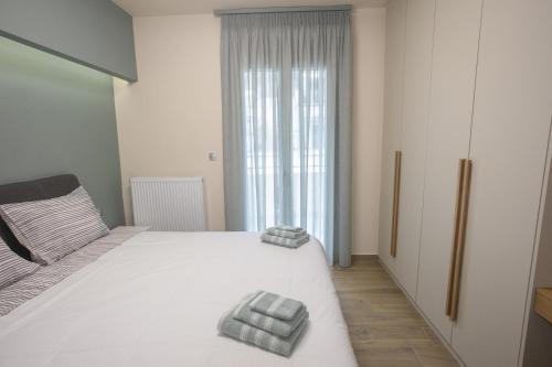 Un dormitorio con una cama con dos toallas encima. en Larissa Luxury Suite, en Larisa