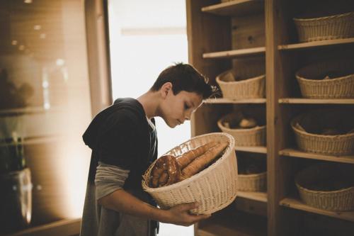 a young man holding a basket of bread in a shelf at Arabella Retreat & Spa in Nauders