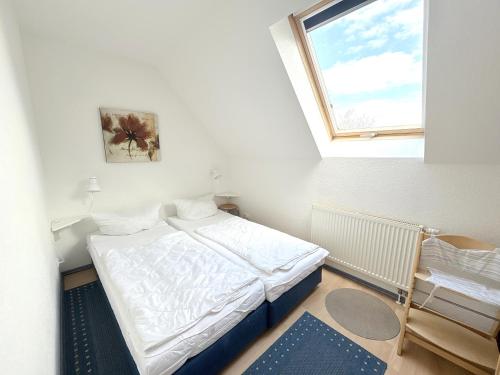 a small bedroom with a bed and a window at Ferienwohnung Sonnenperle - Wohnung 13 in Breege