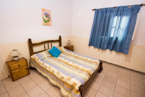 1 dormitorio con 1 cama con cortina azul en Casa Guaymare en Mendoza