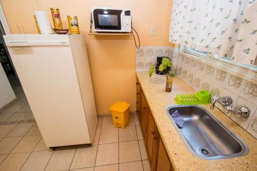 a small kitchen with a sink and a microwave at Casa Guaymare in Mendoza