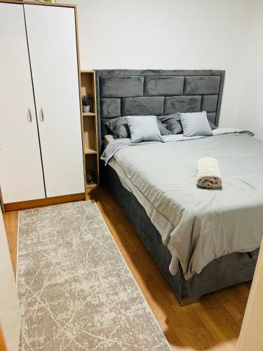 a bedroom with a large bed and a white cabinet at Holiday House Maya in Mostar