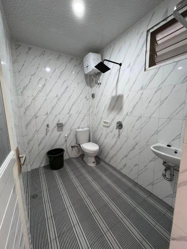 a bathroom with a toilet and a sink at Abadi Guest House Tuktuk in Tuktuk Siadong