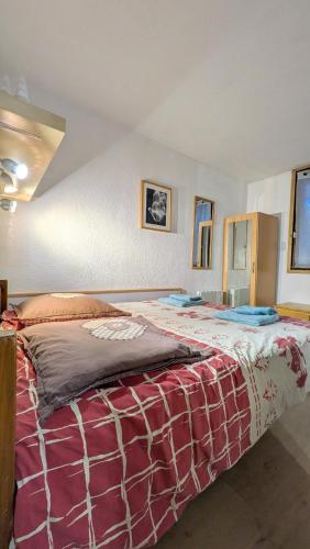 sypialnia z dużym łóżkiem i czerwonym kocem w obiekcie L'alpage w Chamonix-Mont-Blanc