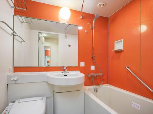 a bathroom with a sink and a toilet and a mirror at Comfort Inn Sano Fujioka Inter in Sano
