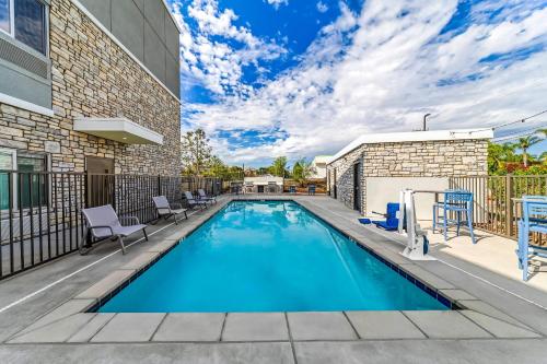 a swimming pool with chairs next to a building at Everhome Suites Ontario in Ontario