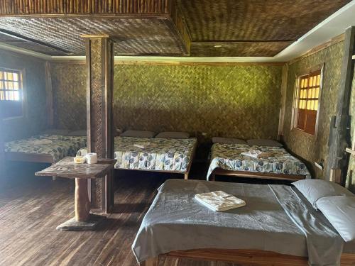 a room with two beds and a table in it at Waddy Inn and Leisure Farm in Taytay