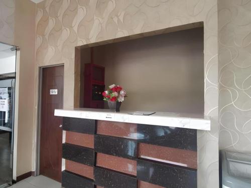 a brick wall with a fireplace with a vase of flowers at Alia Express Sendayan in Kampong Gadong Jaya