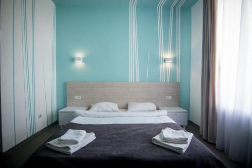 1 dormitorio con 1 cama grande y toallas. en Volna Hotel, en Odessa