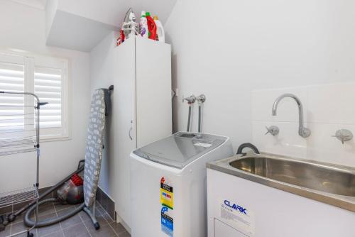 Callala BeachにあるSunkissed Manor - Swimming Pool - 3 Mins to Beachのシンクと冷蔵庫付きのキッチン