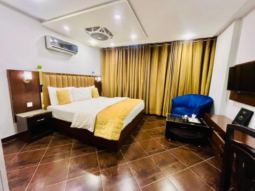 um quarto com uma cama, uma escrivaninha e uma cadeira em Hotel in Multan em Multan