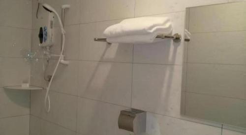 a white towel hanging on a wall in a bathroom at Hotel Pangkor Mutiara in Pasir Bogak