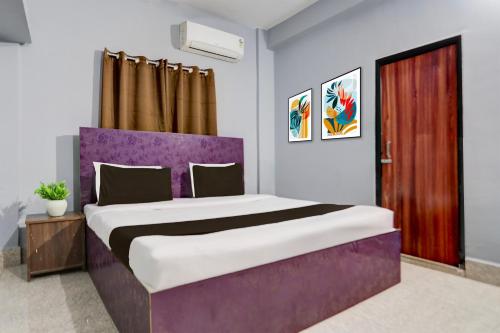 MancheshwarHotel O Palasuni Bridge Bhubaneswar Formerly Ganpat的卧室里有一张带紫色床头板的大床