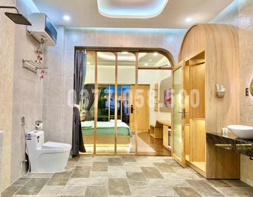 um banheiro com um vaso sanitário, uma pia e uma cama em Sea House Hotels and Apartments em Vung Tau