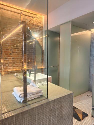 a bathroom with a glass shower and a sink at Loke Thye Kee Heritage Hotel, Georgetown Penang in George Town